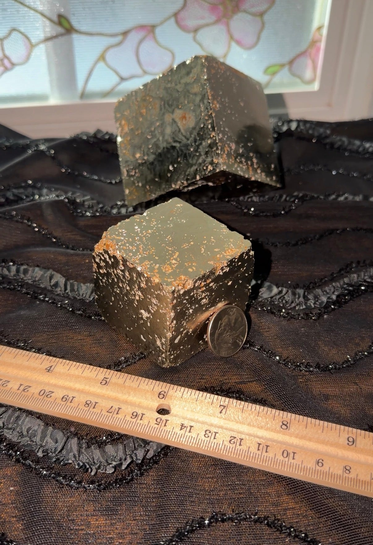 Gold/Metallic pyrite cube displayed with ruler and quartz leaned against it to show mirror-like surace.