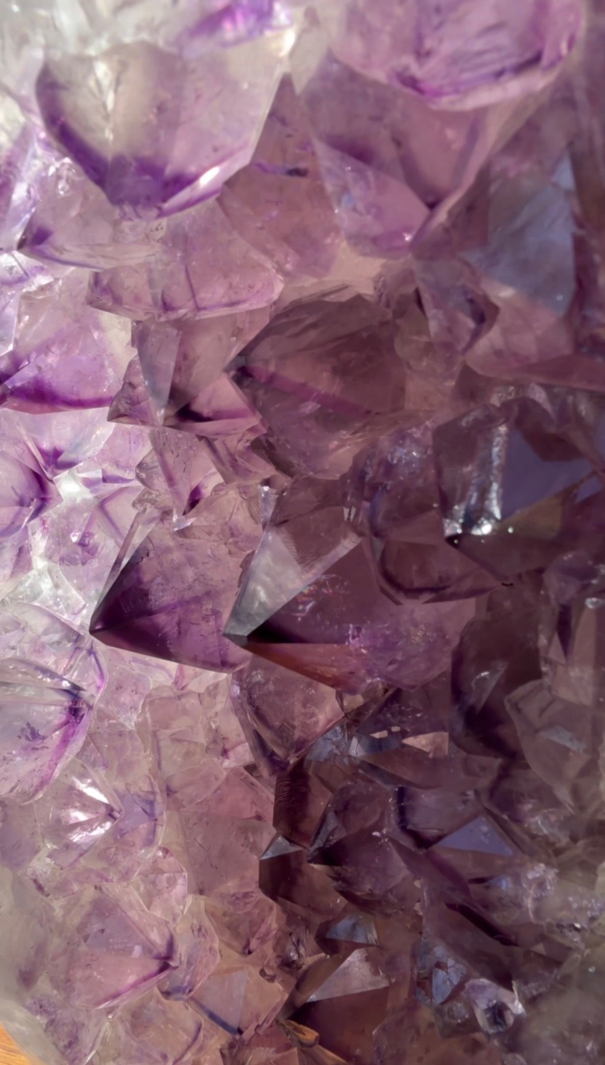 Close-up of a purple phantom point crystal cluster with faceted translucent stones in shades of lavender, violet, and lilac.
