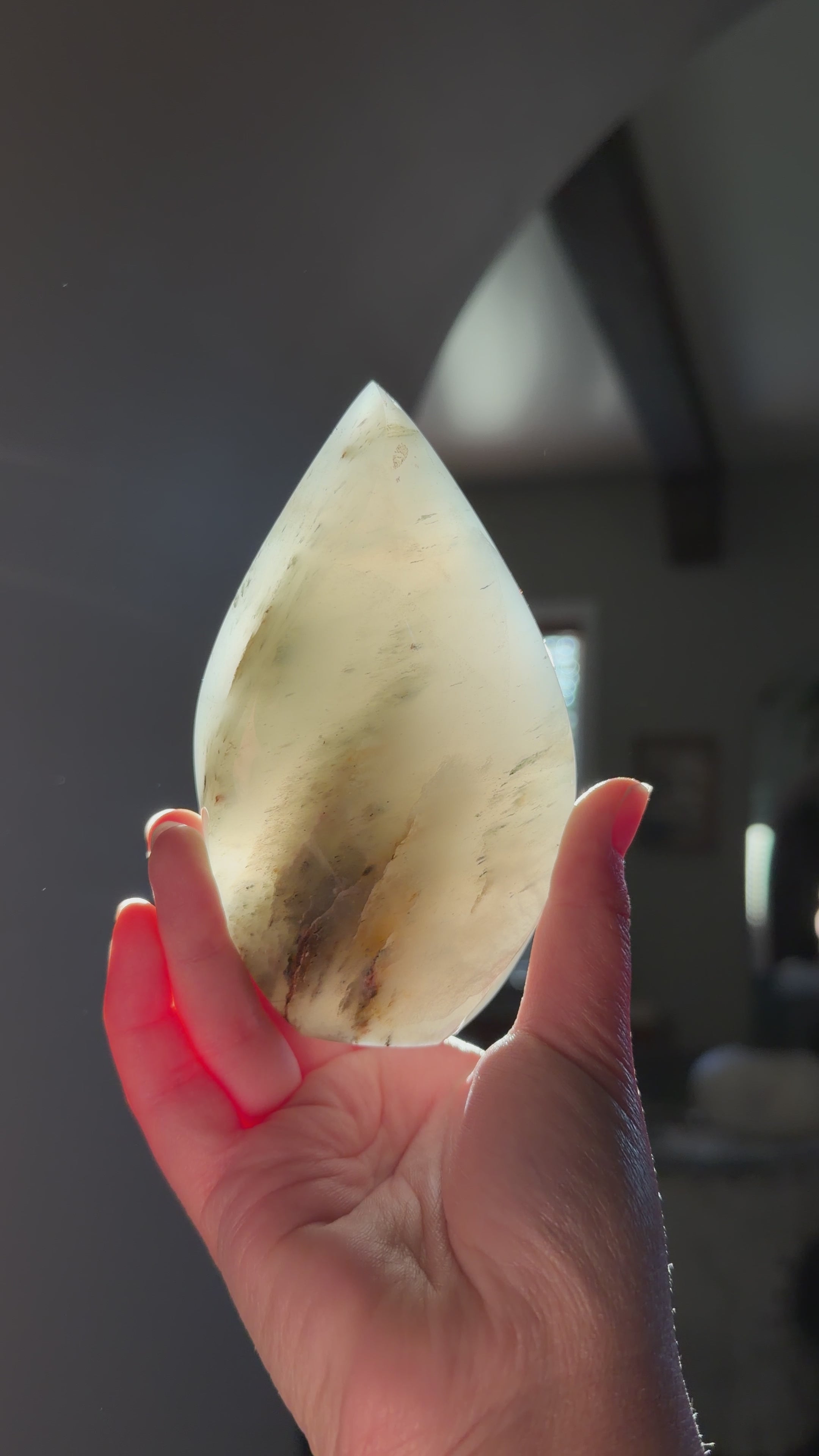 Flame held against sunlight to highlight the color and clarity. Foggy grey and brown garden inclusions. 