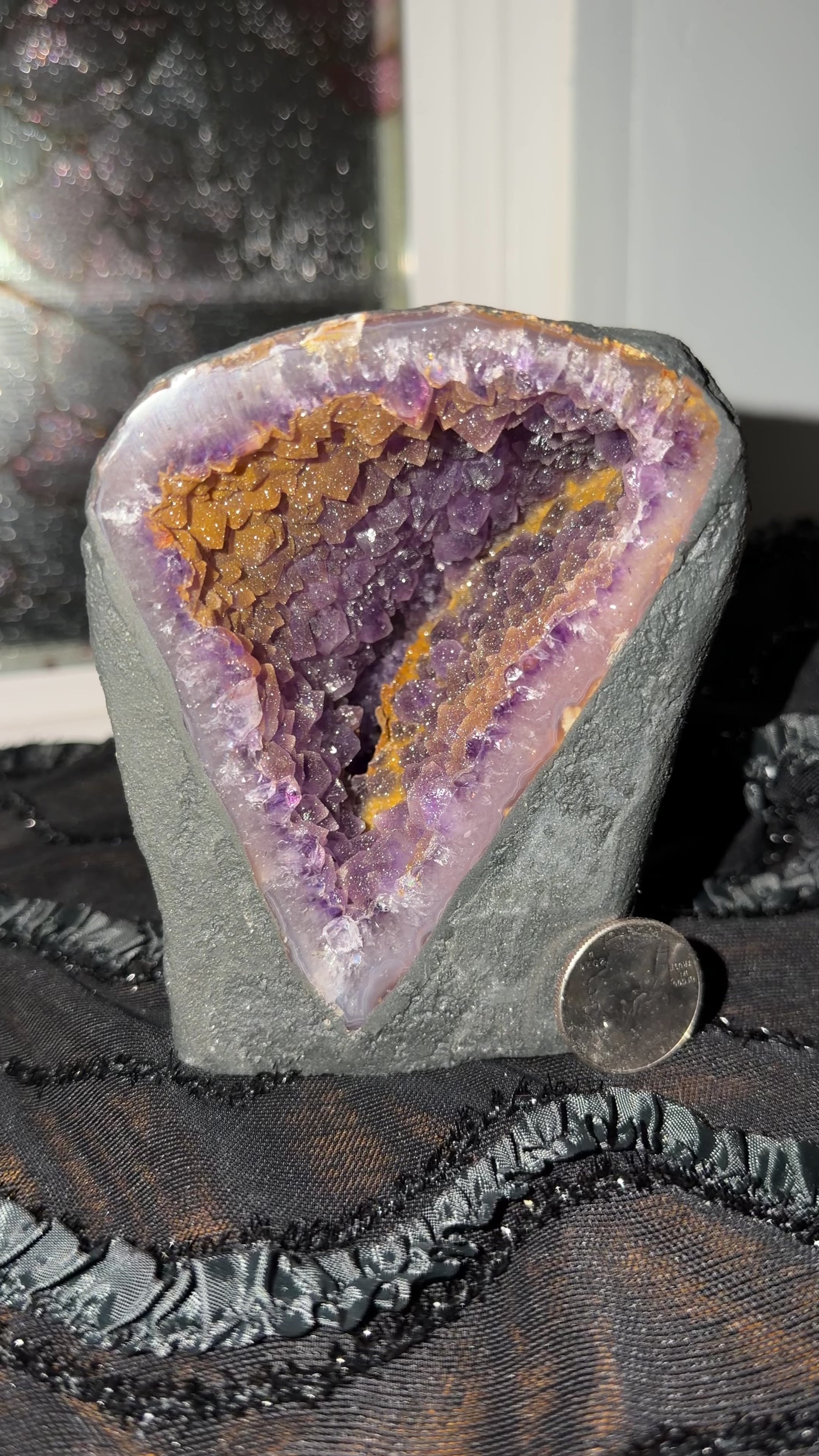 Extremely shimmer druse purple amethyst cluster with golden druse scattered throughout the geode cave. Geode is encased in black cement to create a self standing cathedral.
