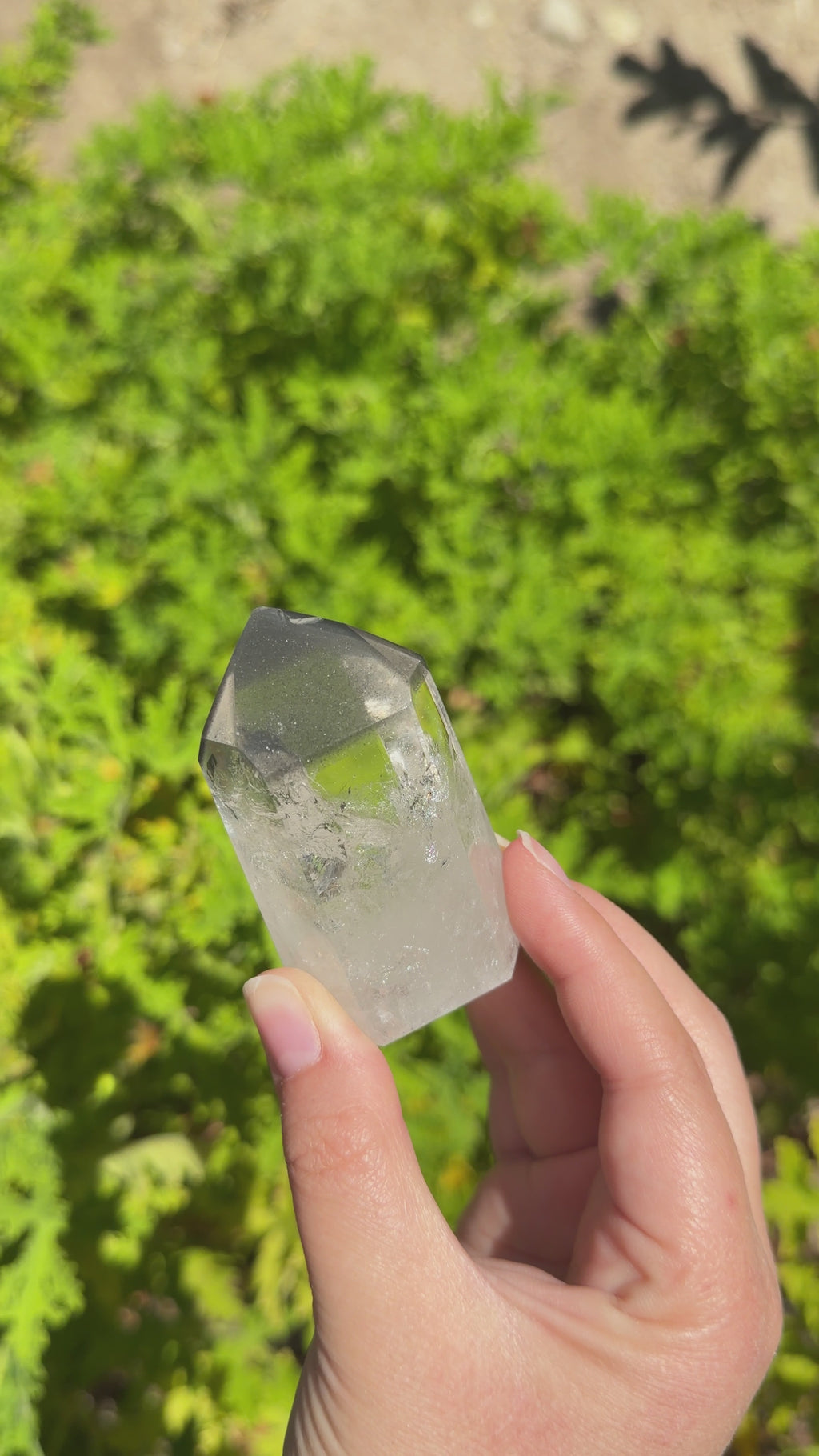 Black lithium phantom point clear quartz tower from Brazil. Filled with rainbows and strong black lithium inclusions. 3 inch tall.