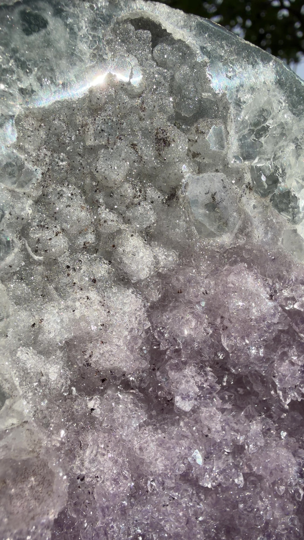 Close up highlighting the inner pink points, druzy white quartz, and black hematite growth. 