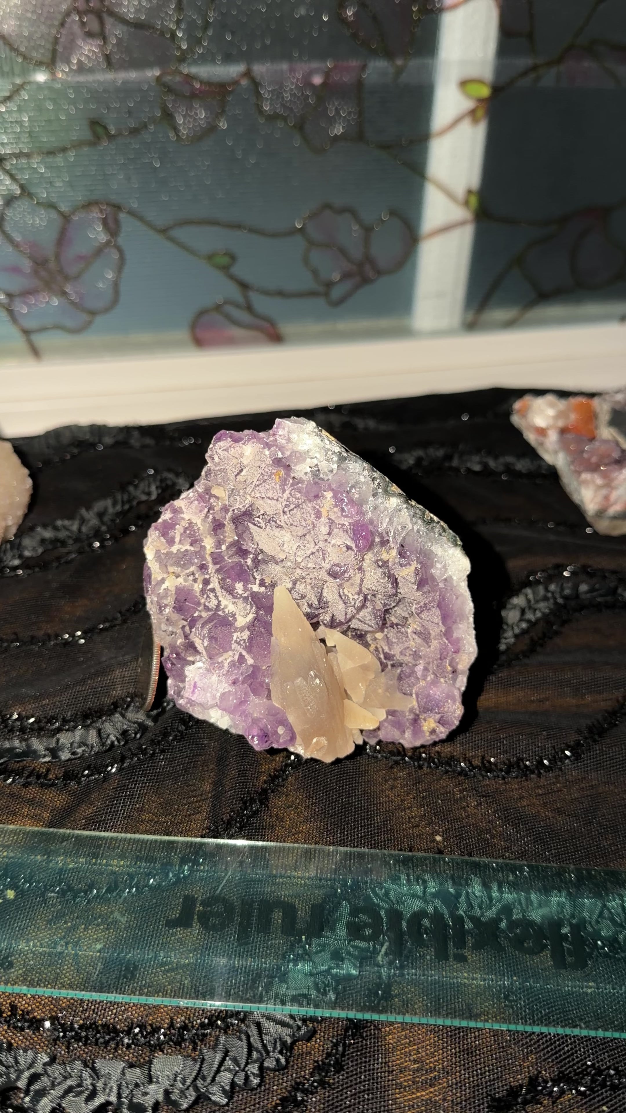Upright standing yellow dogtooth calcite cluster formed on a purple amethyst point cluster. Ruler and quarter in view for size reference. 