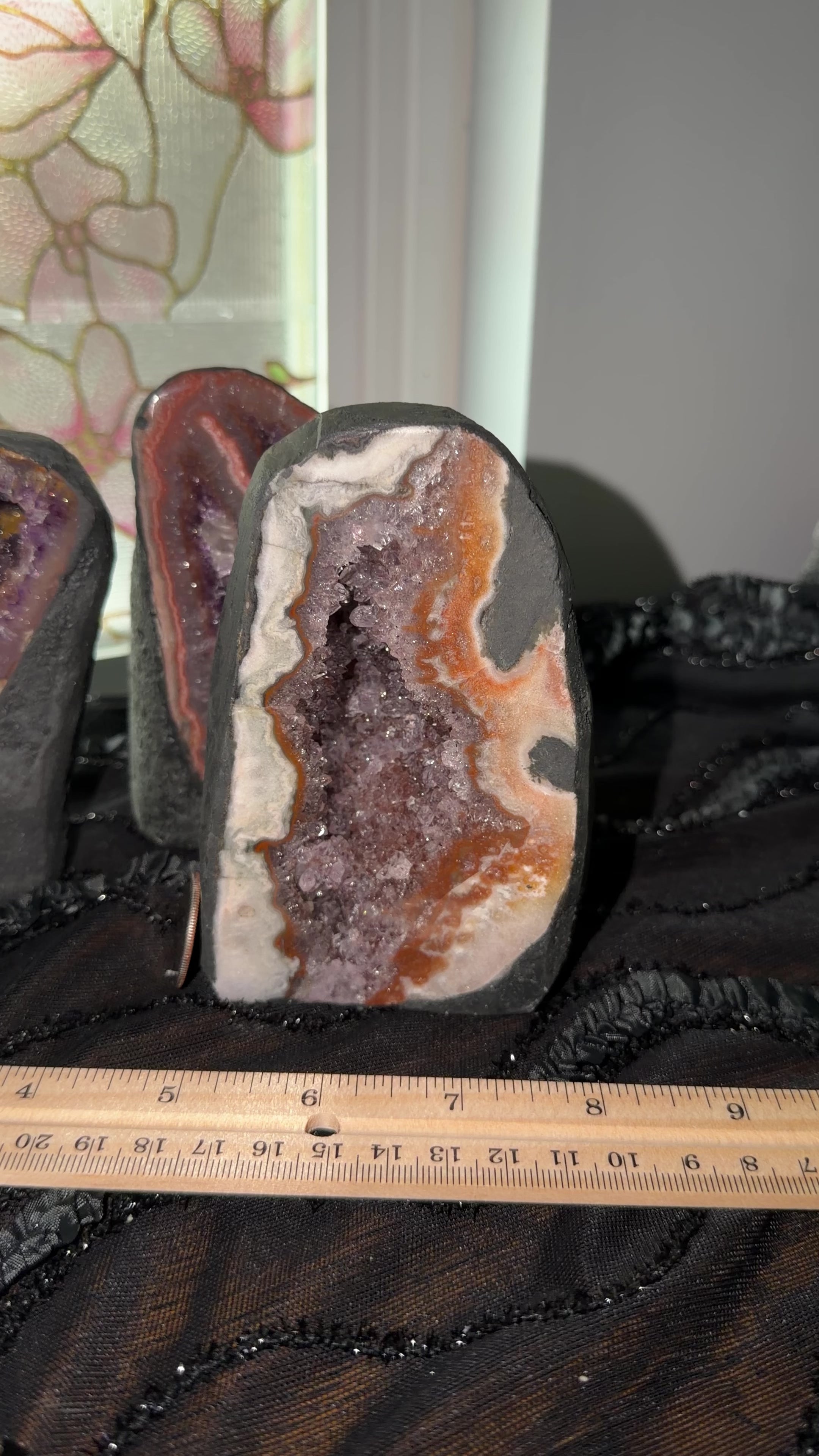 Uruguayan purple amethyst with peach, orange, green agate banding encased in cement to display as a self standing cathedral.